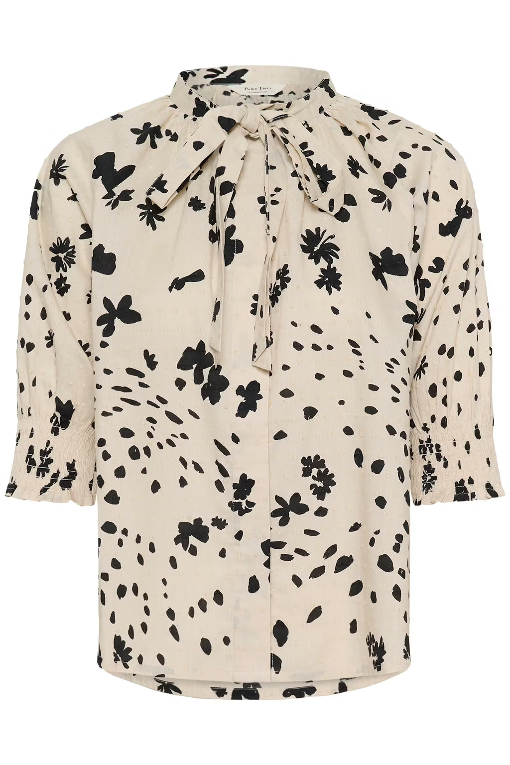 Beige blouse with black floral pattern on a white background