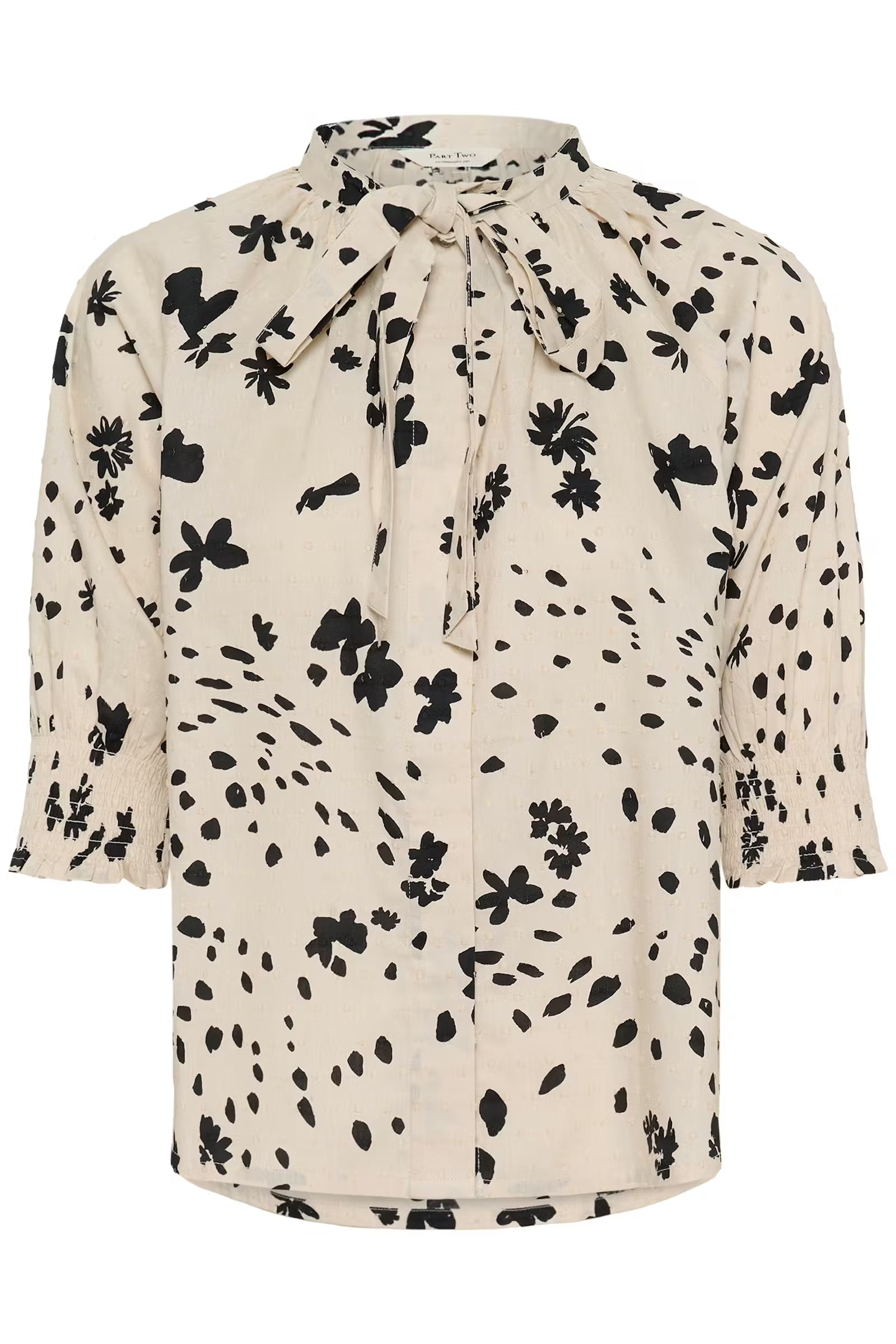 Beige blouse with black floral pattern on a white background