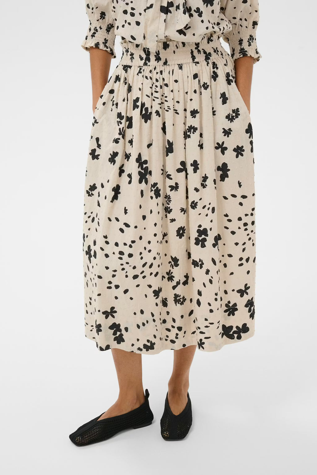 Person wearing a floral dress on a white background