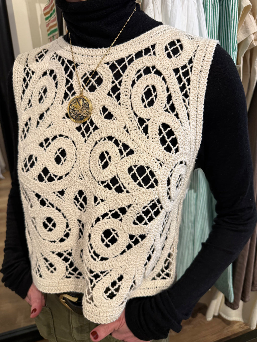 Person wearing a cream-colored crochet vest over a black turtleneck. 

knit vest, knit crochet tank top, knit crochet top, summer tops, how to wear a spring top in the winter, spring to winter styling 