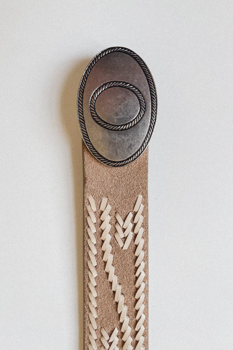 Decorative belt with leather strap and metal buckle on a light gray background, western belt, tan and silver western belt 