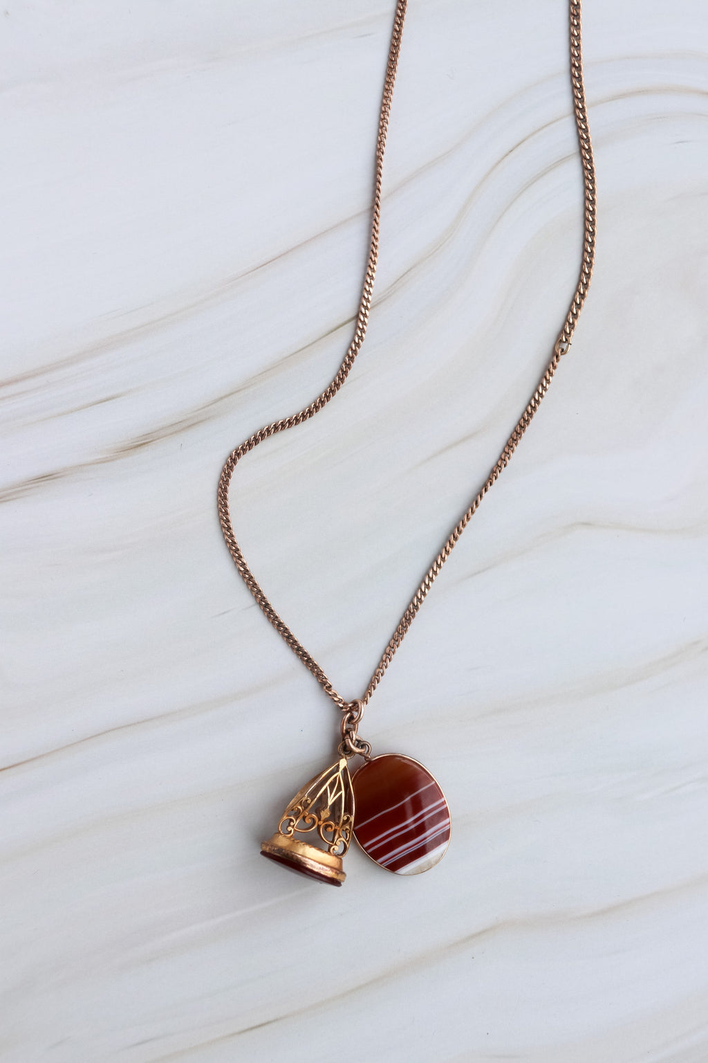 Necklace with a red stone pendant on a white marble surface
