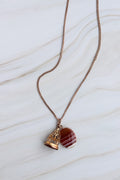 Necklace with a red stone pendant on a white marble surface