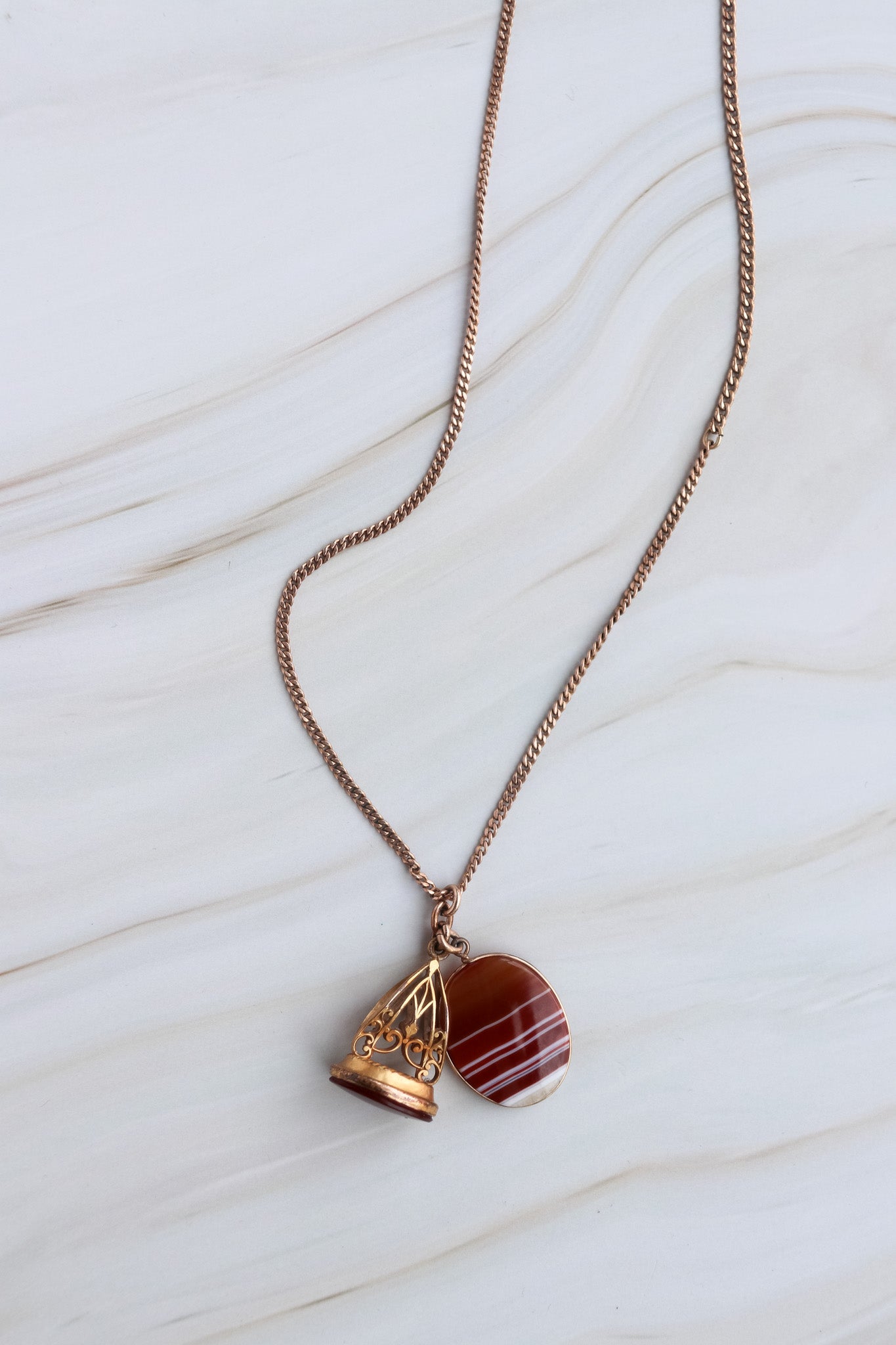 Necklace with a red stone pendant on a white marble surface