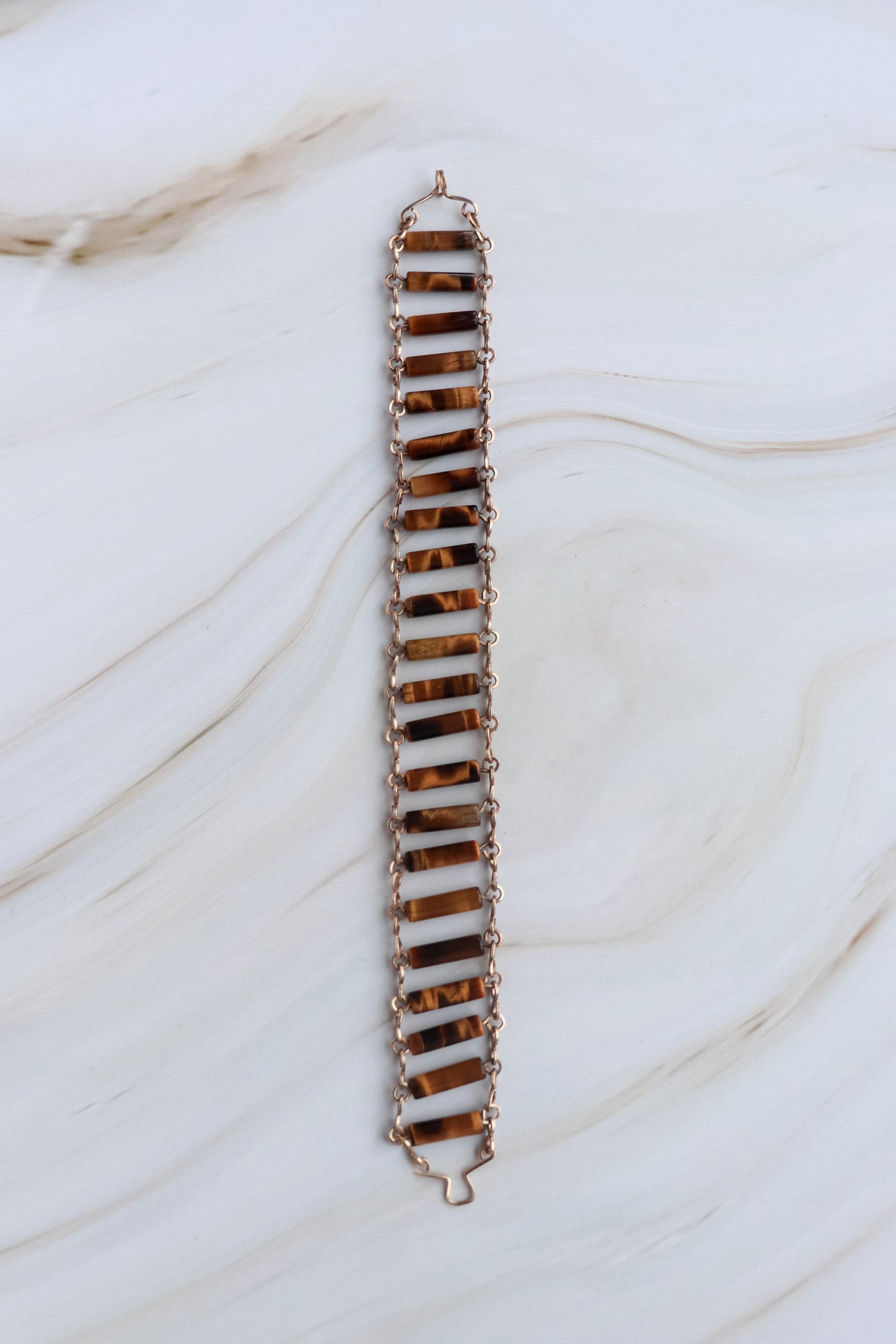 Long, thin bracelet with a zigzag pattern on a marble surface