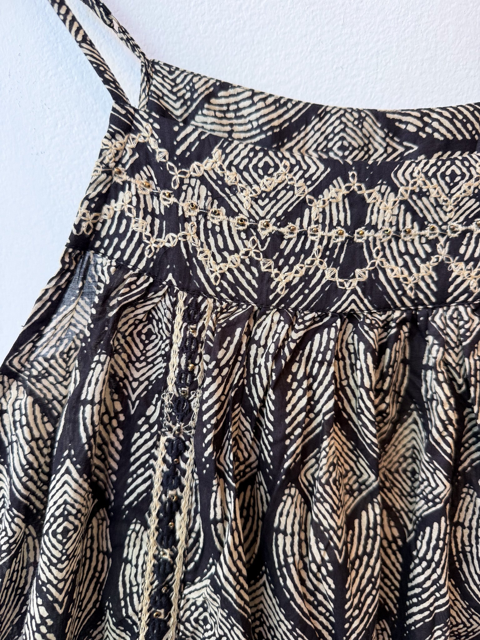 tank top with black and gold geometric pattern on a light blue background with embroidered details and beaded embroidery 