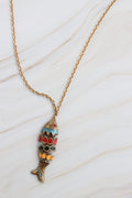 Gold fish-shaped pendant necklace on a white background