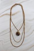 vintage Gold necklace with a pendant on a marble surface