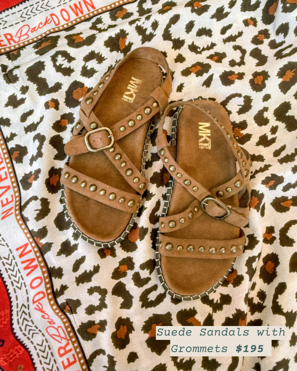 Pair of suede sandals with grommets on a leopard print surface