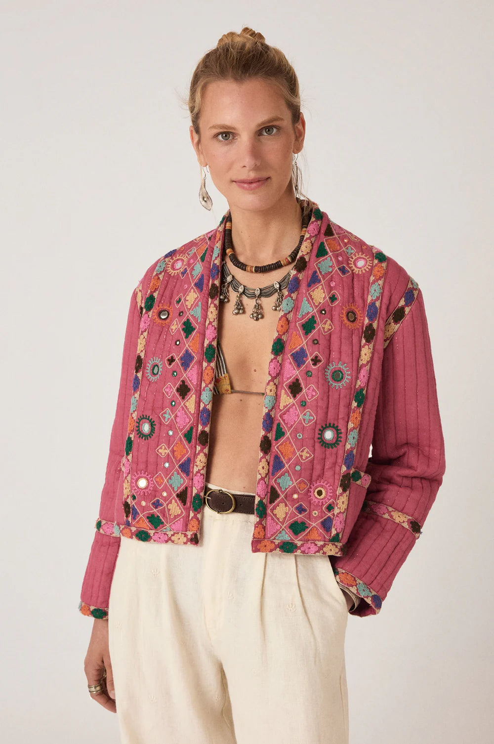 Woman wearing a colorful embroidered padded quilited jacket on a white background. dopamine dressing, boxy cut jacket, oversized fit jacket, light jacket, light cardigan for spirng, light spring layers 