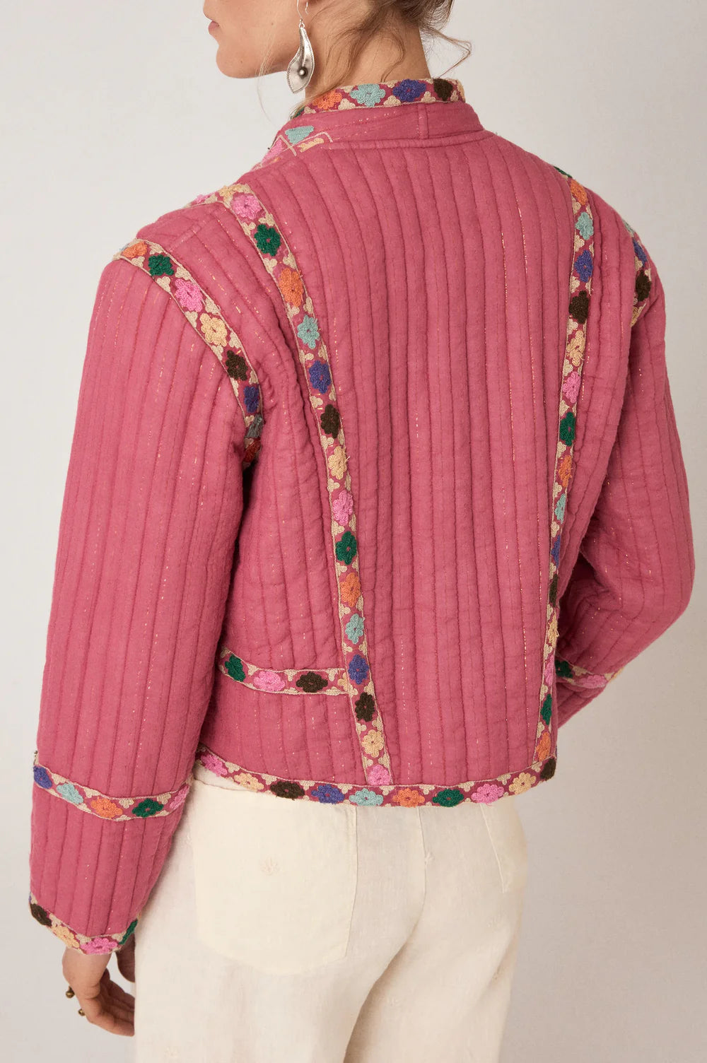 Pink jacket with colorful embroidery on a plain background