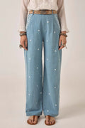 Person wearing light blue denim pants with white floral patterns on a plain background. Western bottoms, western trousers, western pants 