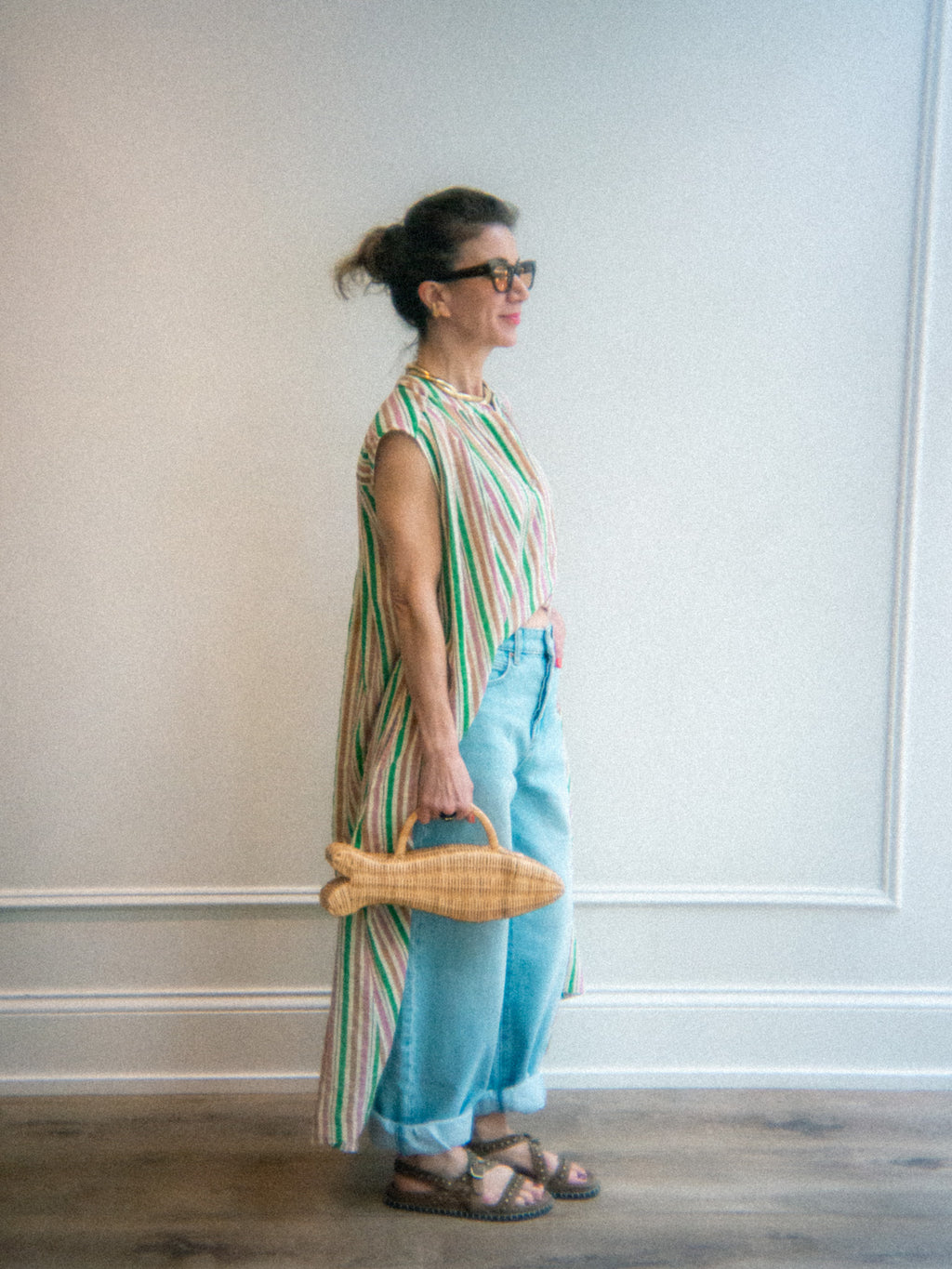 stripe kimono styled button down dress layered over jeans with a statement fish bag and grommet sandals 