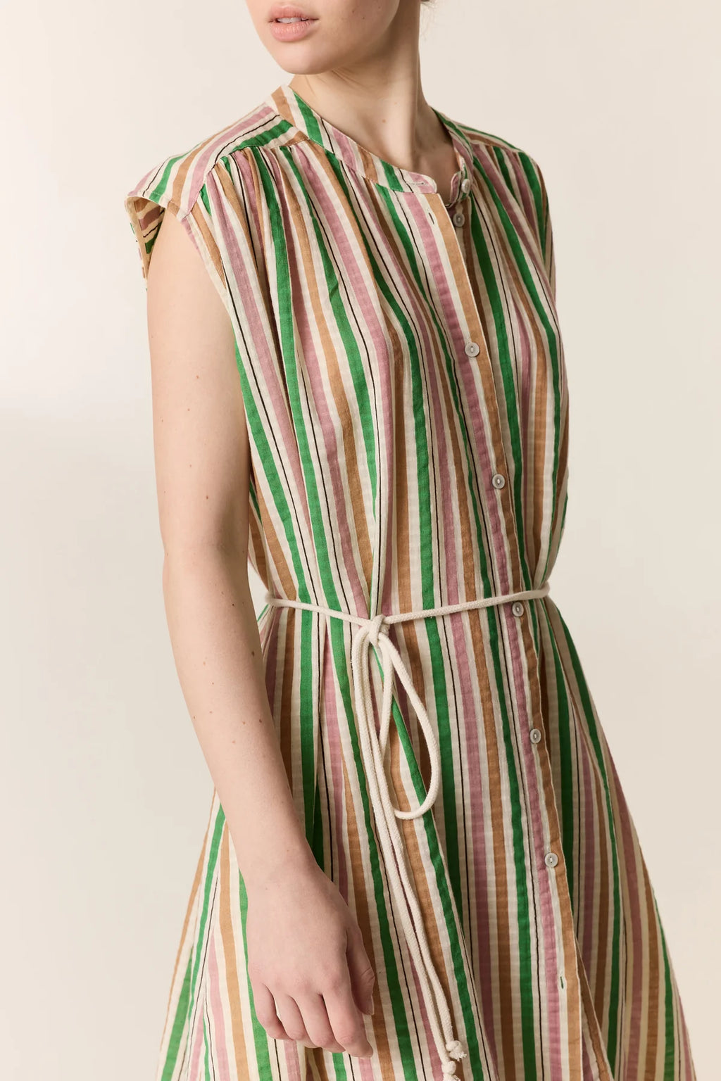 Striped dress with a belt on a plain background