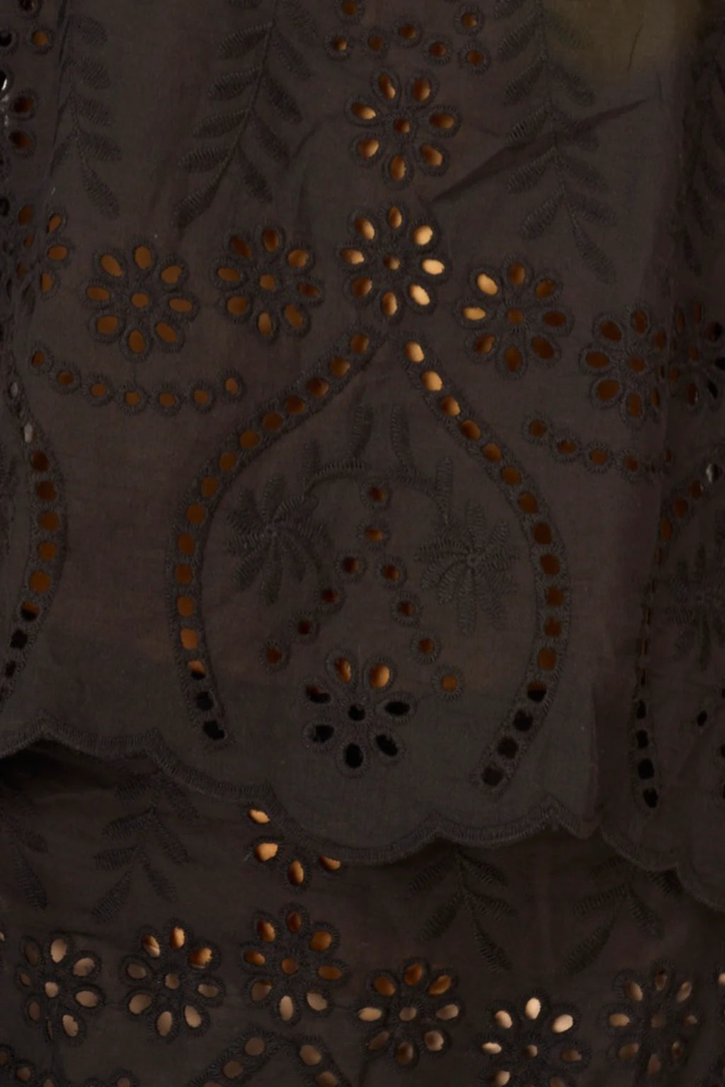Close-up of a dark fabric with intricate gold embroidery