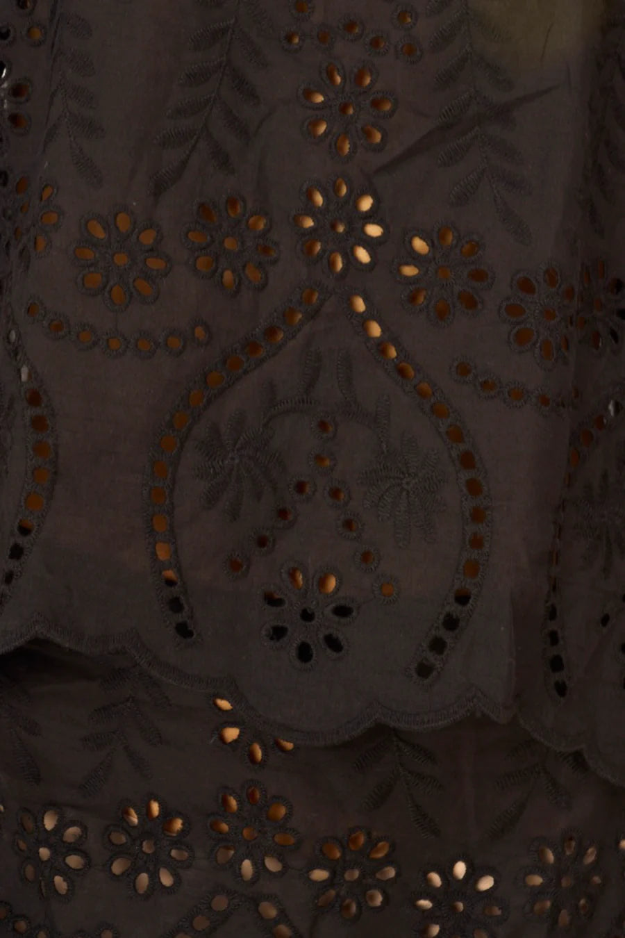 Close-up of a dark fabric with intricate gold embroidery