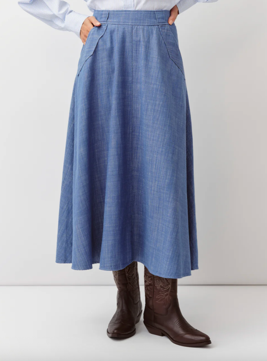 Person wearing a blue checkered skirt and brown boots on a white background