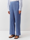Person wearing blue checkered pants and a striped shirt on a white background
