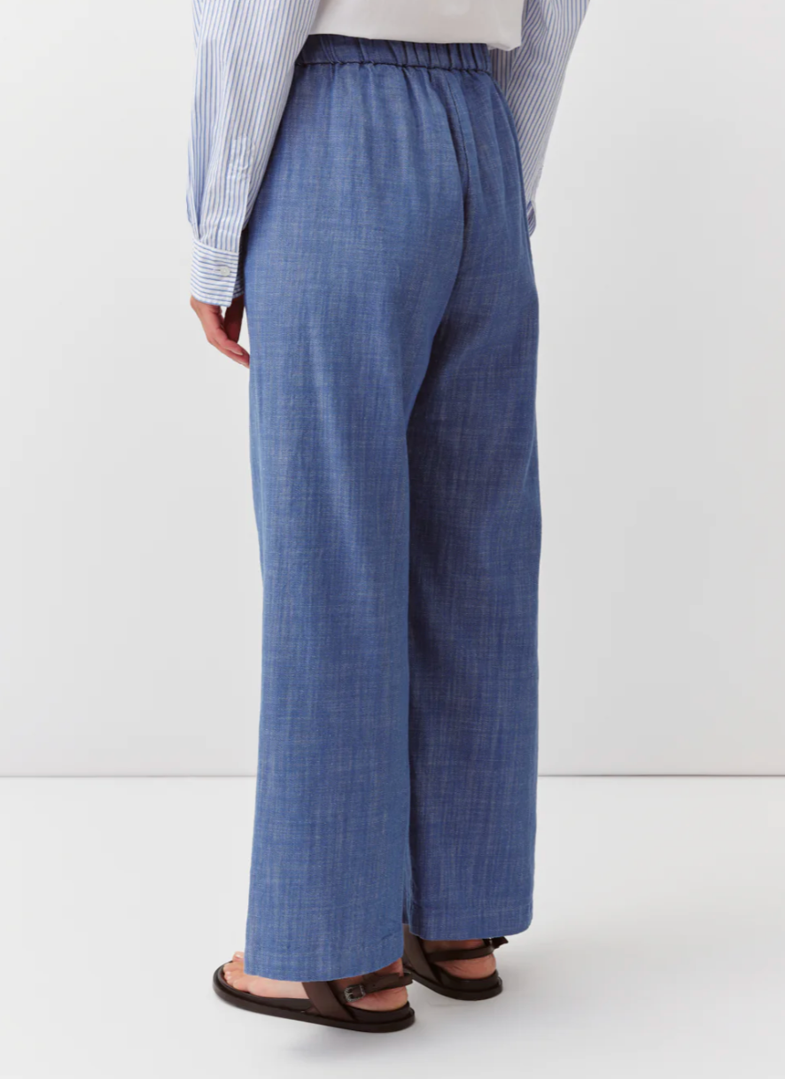 Person wearing blue checkered pants on a white background