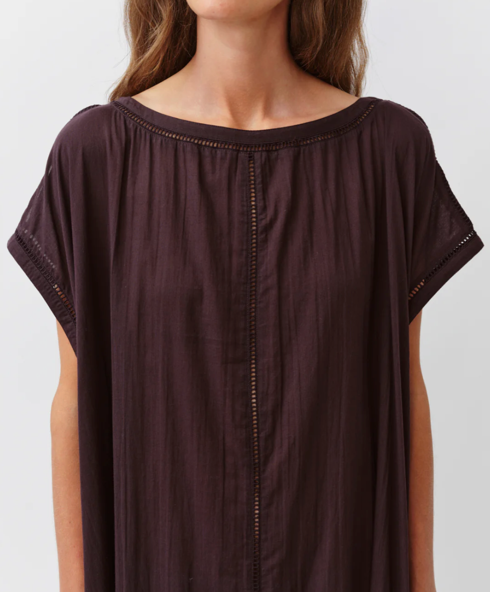 Brown short-sleeve top worn by a person on a white background