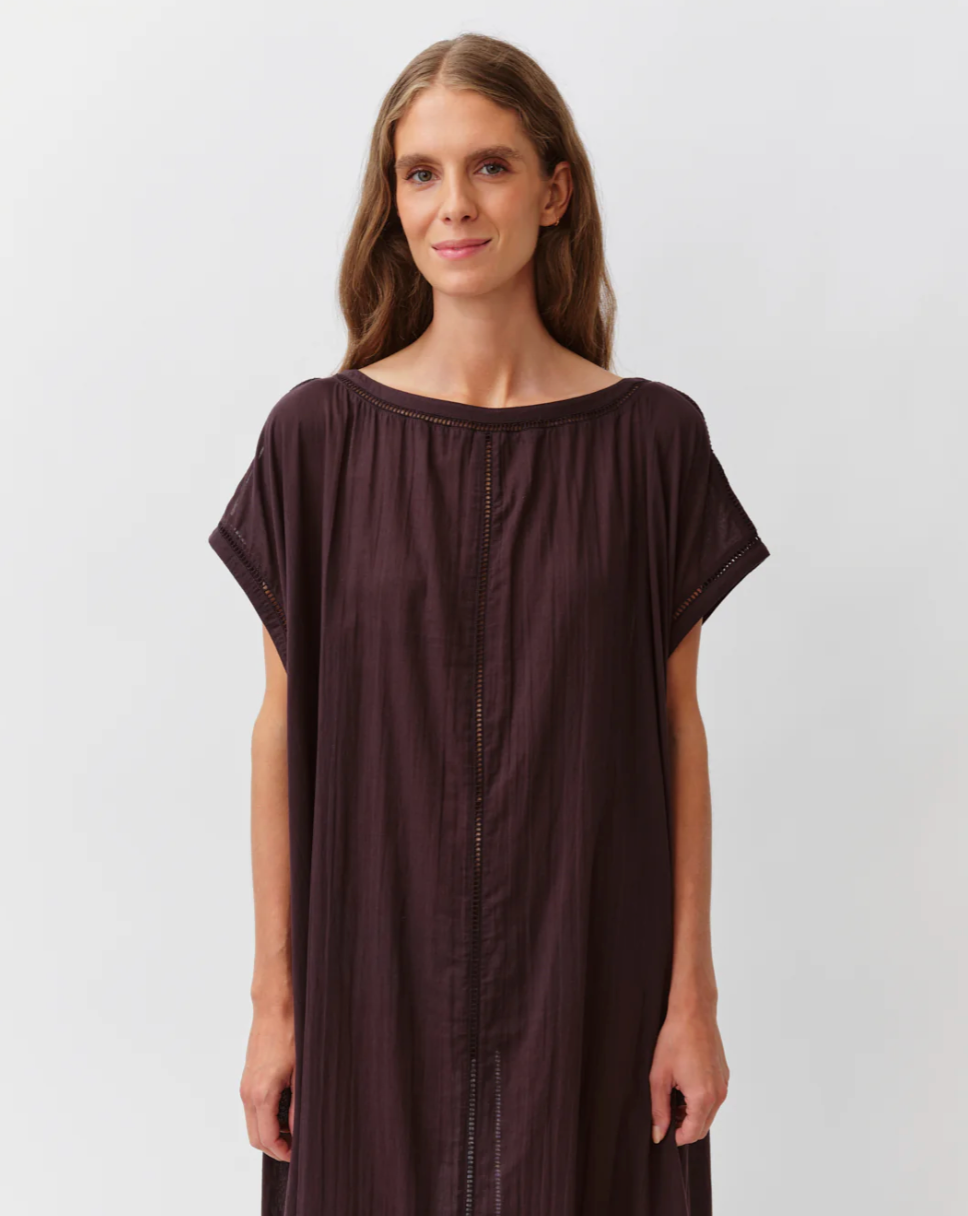 Woman wearing a brown dress against a plain background