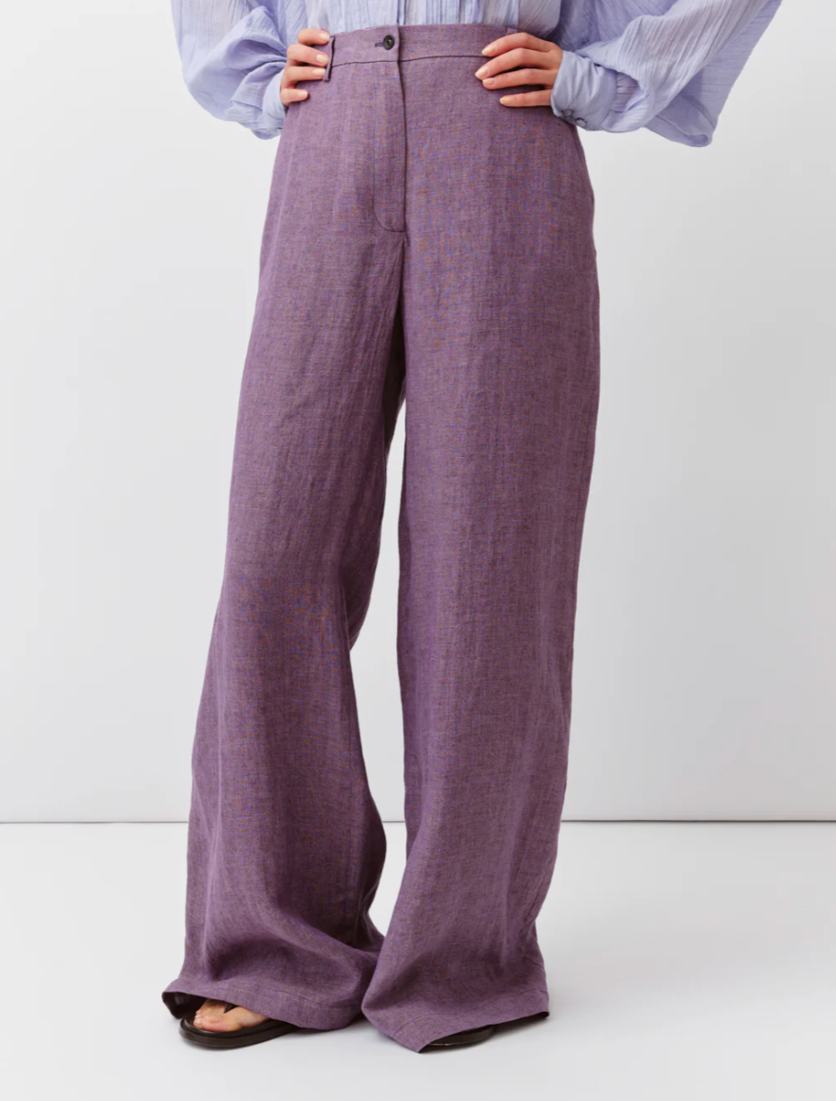 Purple wide-leg pants worn by a person on a white background
