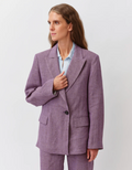 Woman wearing a purple suit against a white background