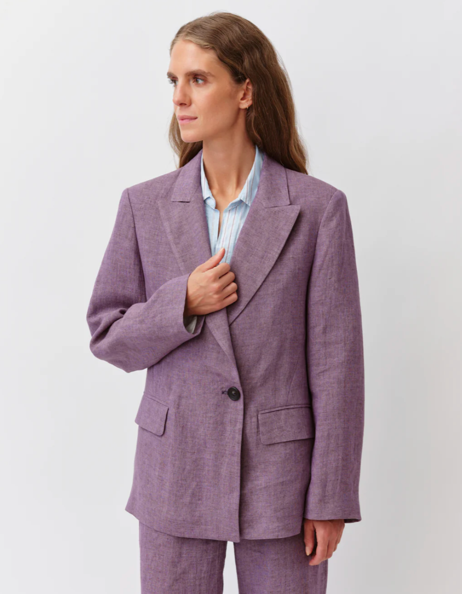 Woman wearing a purple suit against a white background