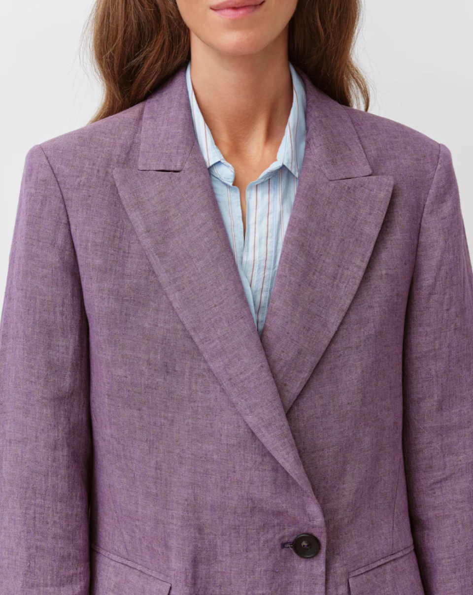 Purple blazer worn by a person on a white background