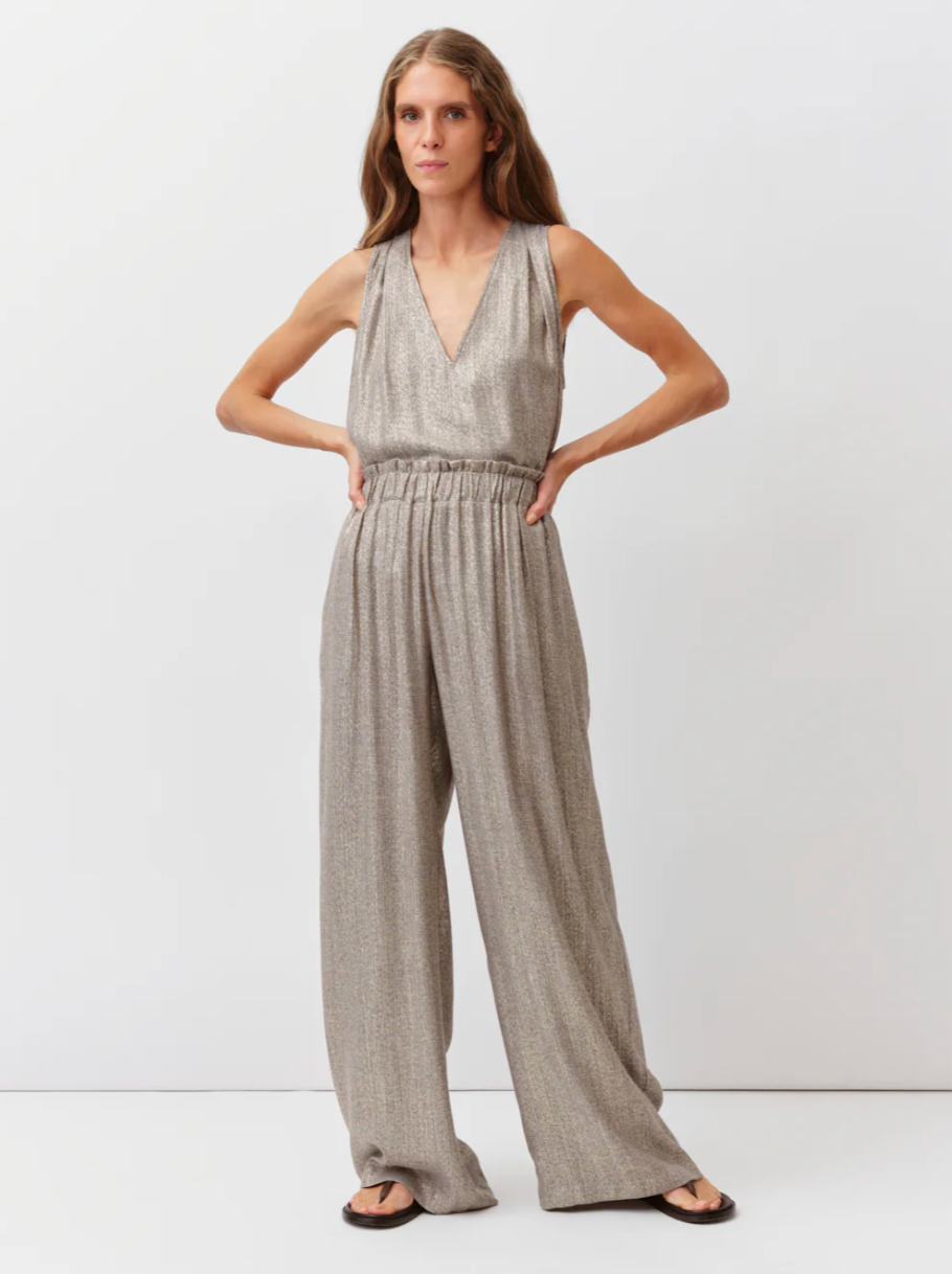 Woman wearing a gray checkered jumpsuit on a white background