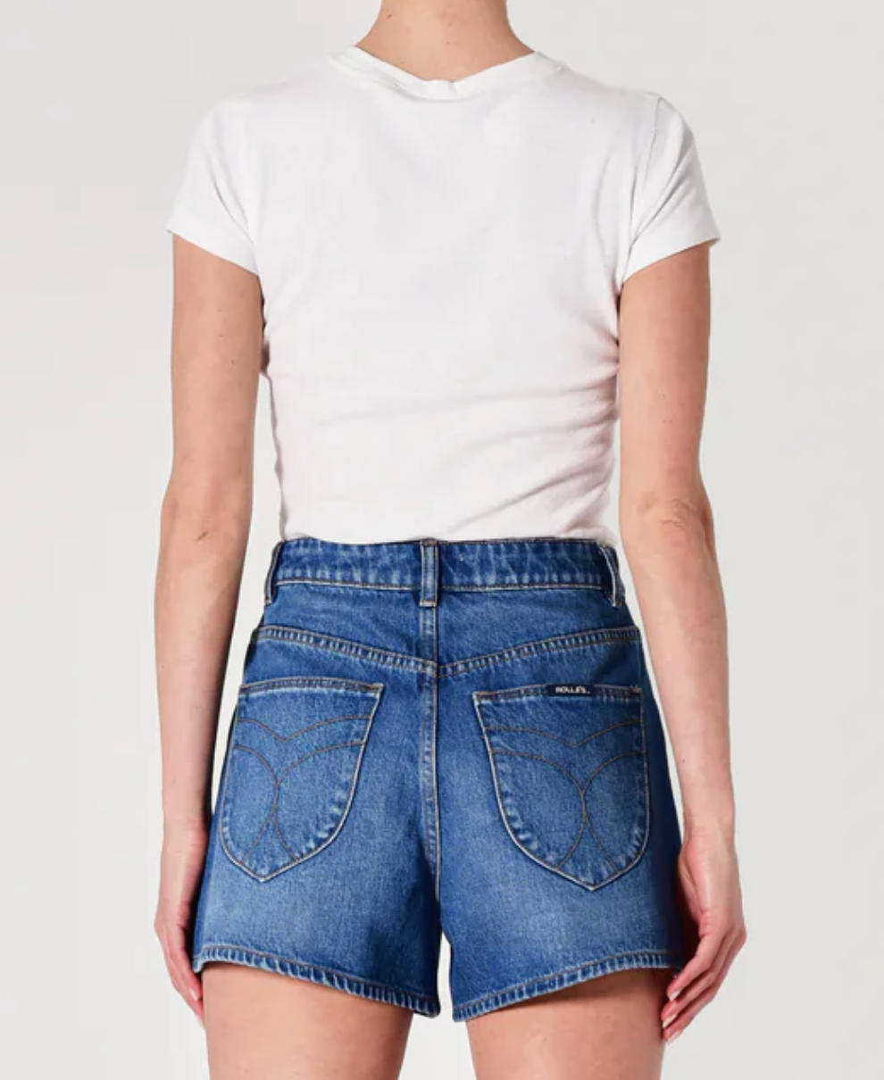 Person wearing a white t-shirt and blue denim shorts on a plain background