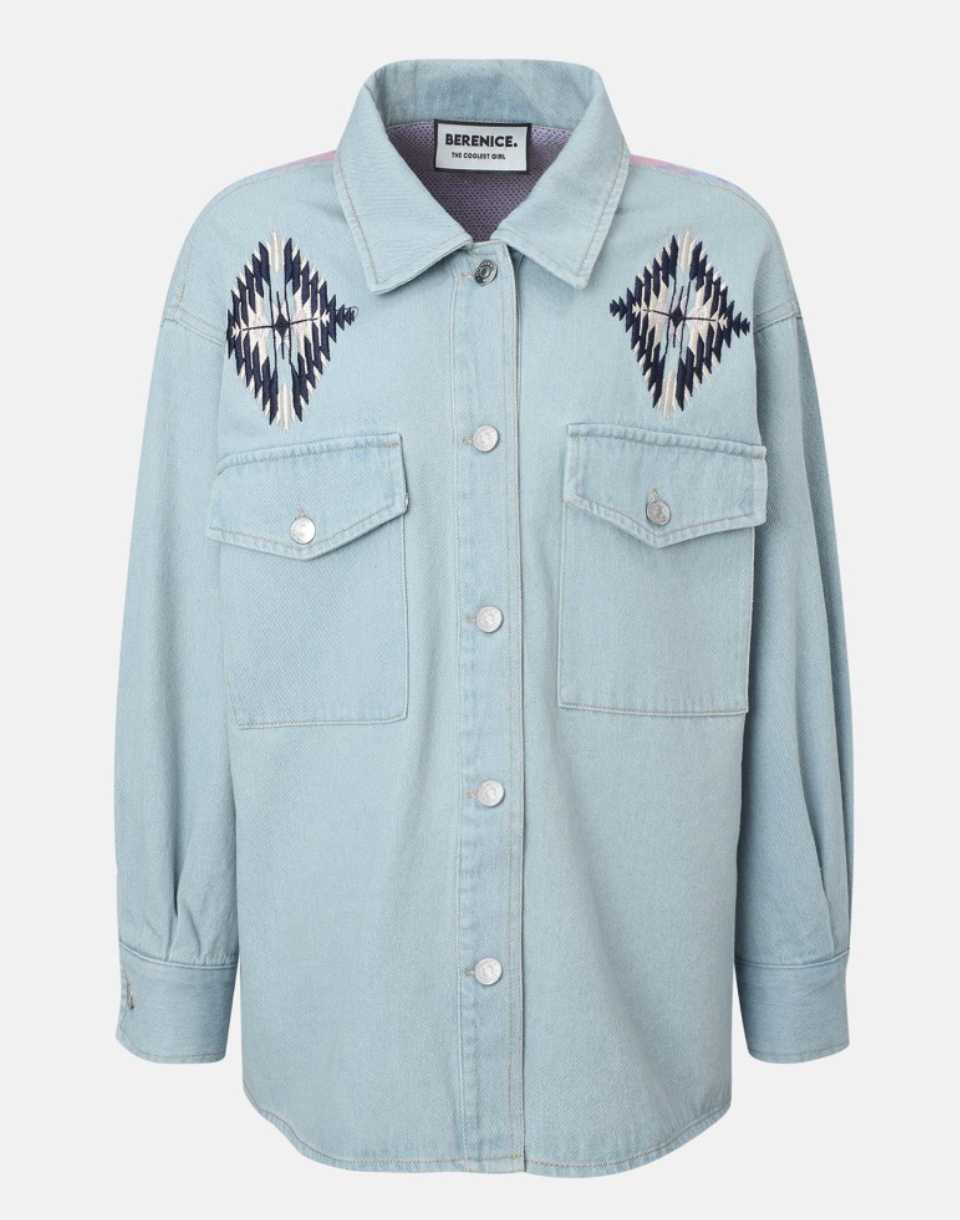 Light blue denim shirt with embroidered patterns on a white background