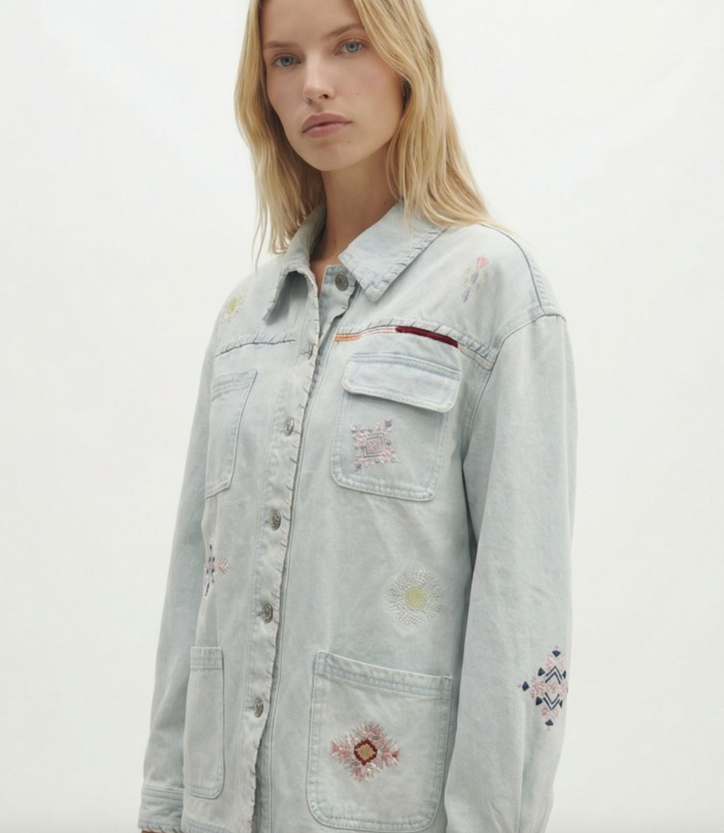 Light denim jacket with floral embroidery on a plain background