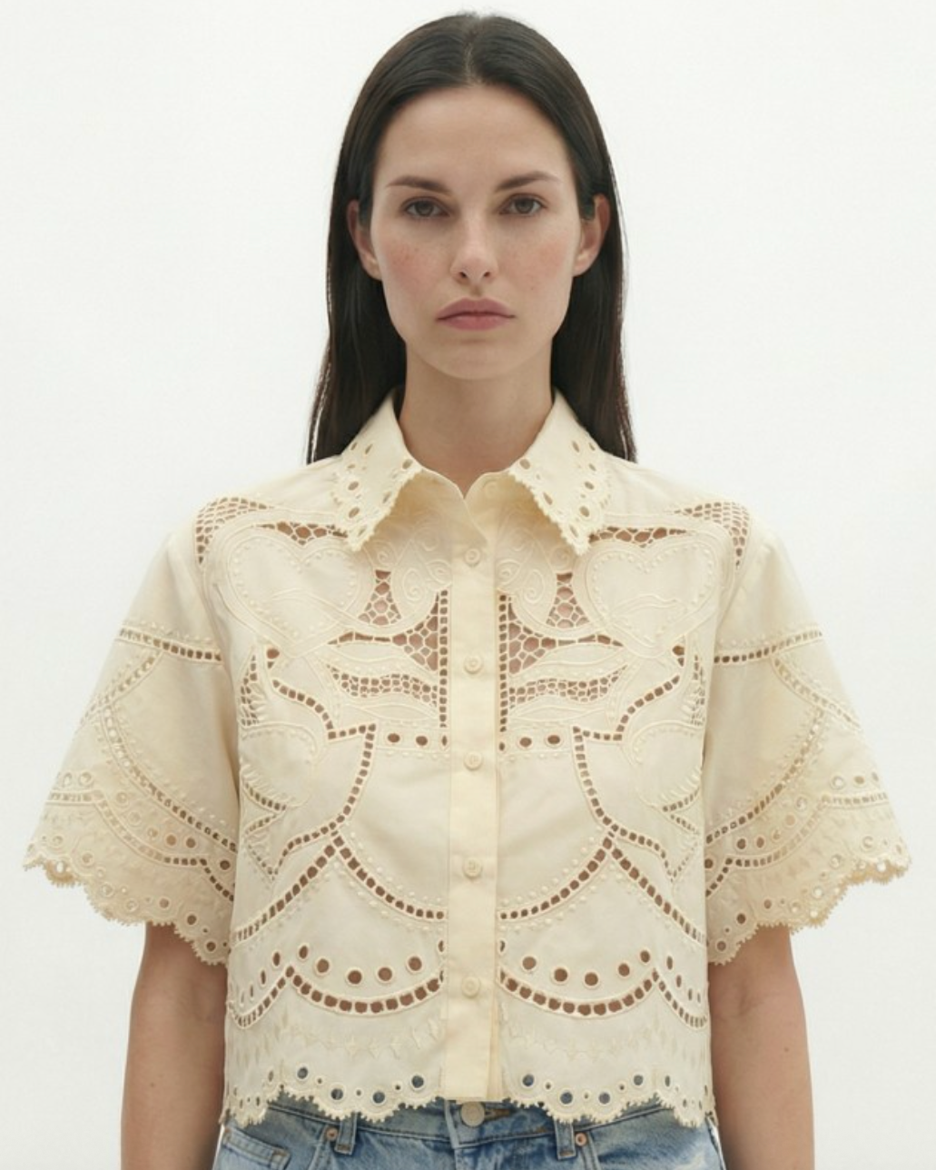 Woman wearing a beige lace blouse on a white background