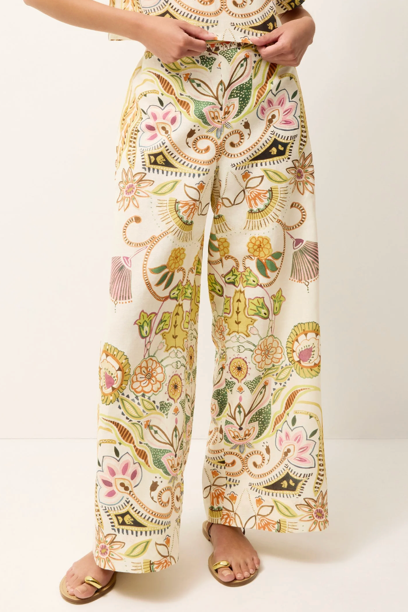 Floral patterned pants worn by a person on a white background