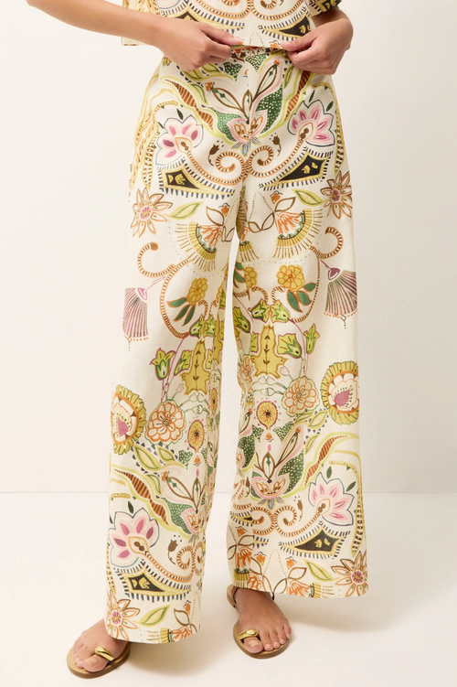 Floral patterned pants worn by a person on a white background