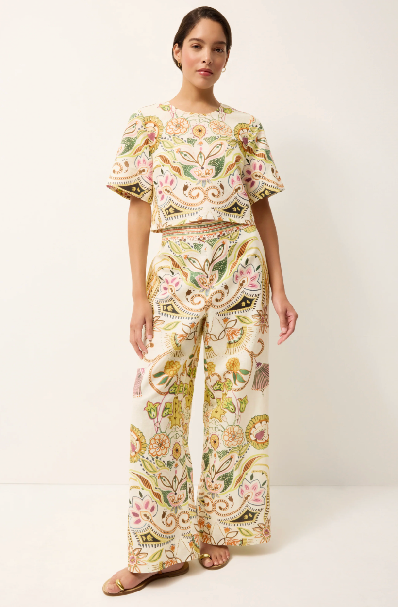Woman wearing a floral embroidered outfit on a white background