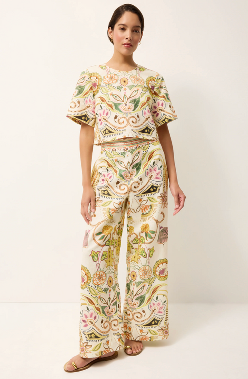 Woman wearing a floral embroidered outfit on a white background