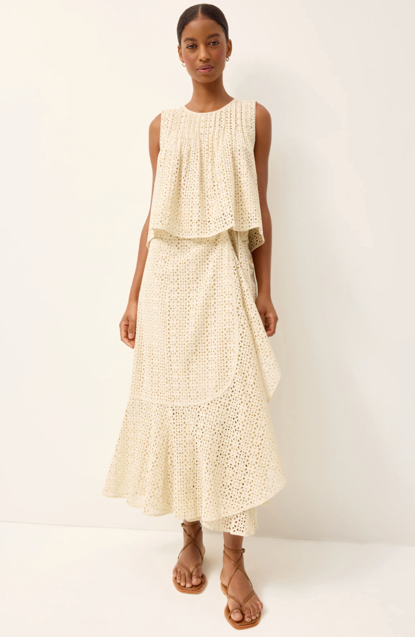 Woman wearing a cream-colored dress with a white background