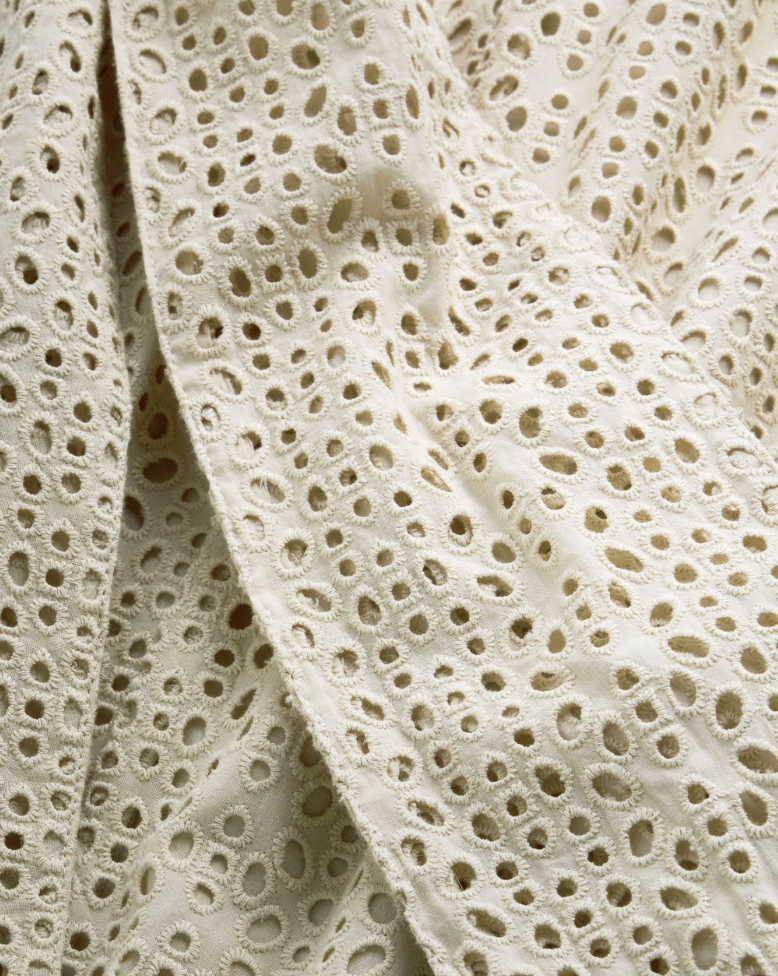 Close-up of beige lace fabric with a detailed pattern