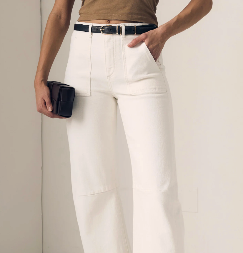Person wearing soft barrel white pants with a plain background