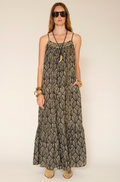 Woman wearing a long patterned dress against a plain background