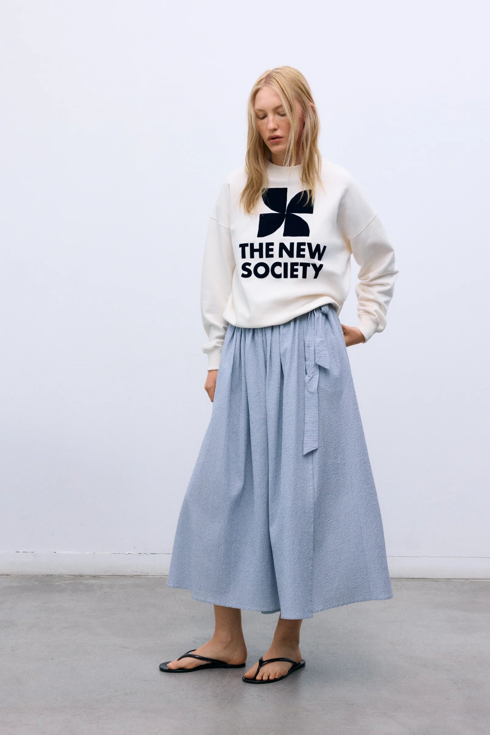 Graphic sweatshirt paired back with a blue and white stripe shirt 