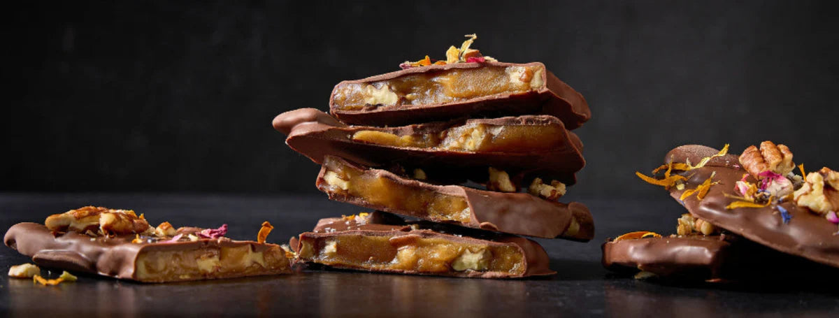 Chocolate-dipped treats with floral toppings on a dark background