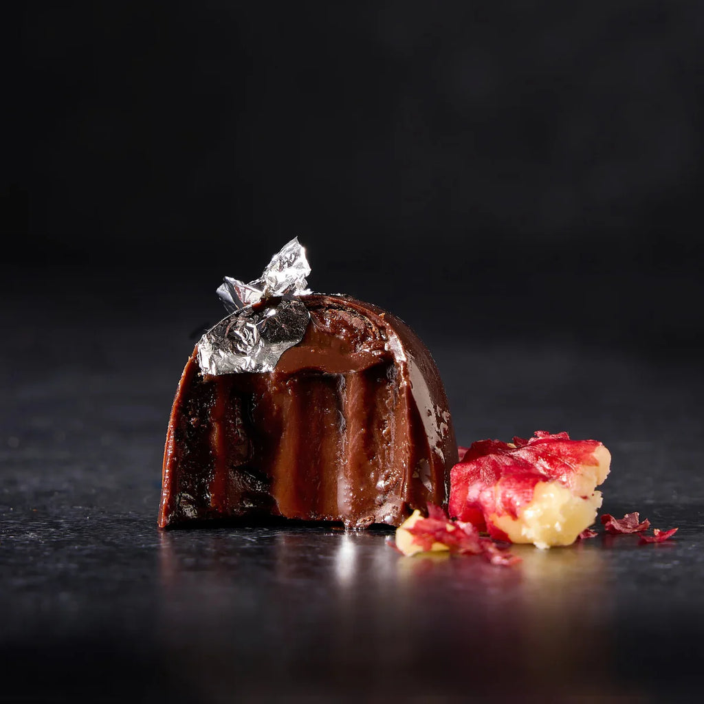 Chocolate dessert with a silver leaf on a dark surface