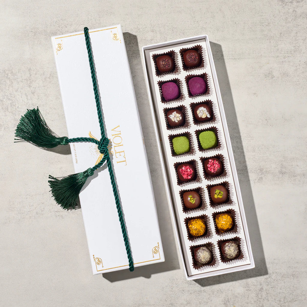 Box of assorted chocolates with a decorative ribbon on a light background