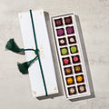 Box of assorted chocolates with a decorative ribbon on a light background