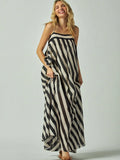 Woman wearing a black and white striped dress on a plain background