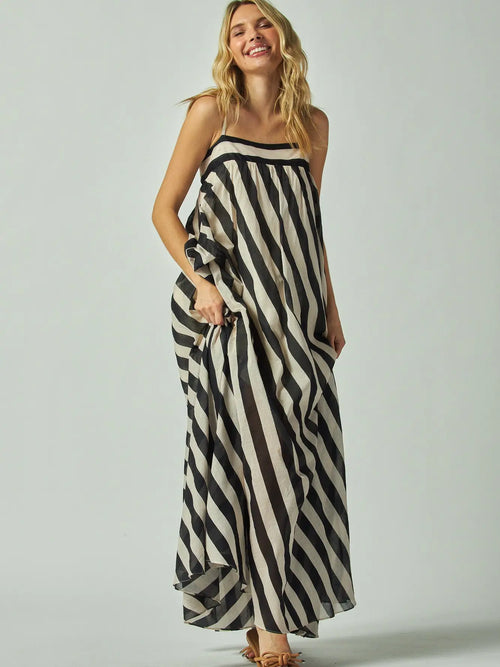Woman wearing a black and white striped dress on a plain background