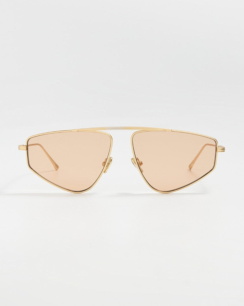 elisa johnson Gold-framed sunglasses with beige lenses on a light gray background